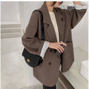 Blazer marrom feminino com caimento amplo, usado com camiseta branca e bolsa preta transversal.