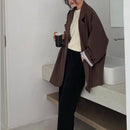 Blazer marrom oversized feminino em ambiente clean, combinação casual com camiseta básica.