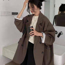 Blazer alongado feminino minimalista na cor marrom, com design oversized e botões frontais.