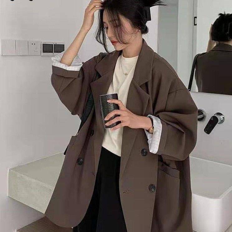 Blazer alongado feminino minimalista na cor marrom, com design oversized e botões frontais.