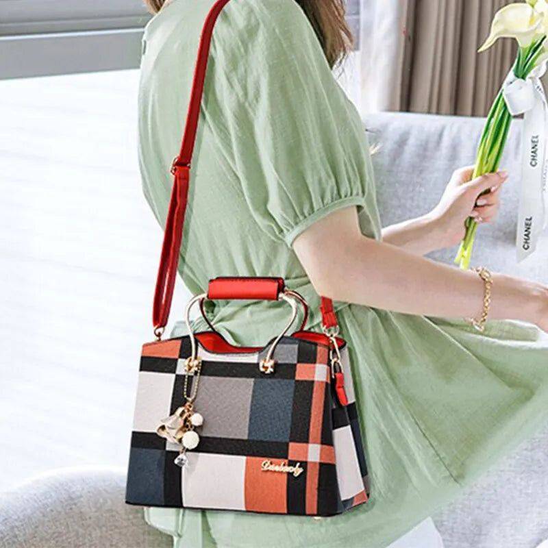 Alt text: Bolsa feminina de couro estruturada com estampa xadrez em tons neutros.