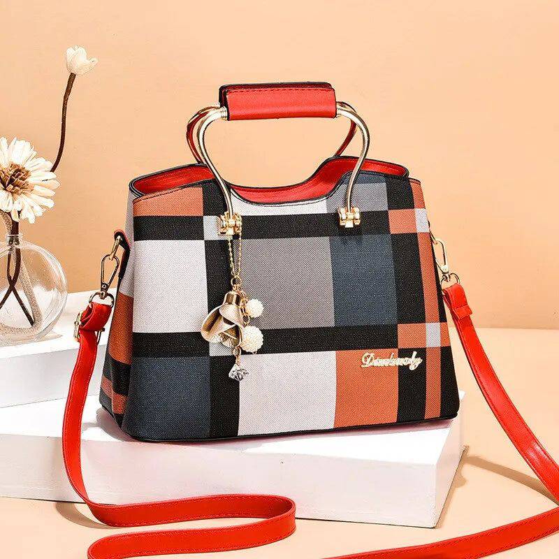 Alt text: Bolsa feminina de couro estruturada com estampa xadrez em tons neutros.