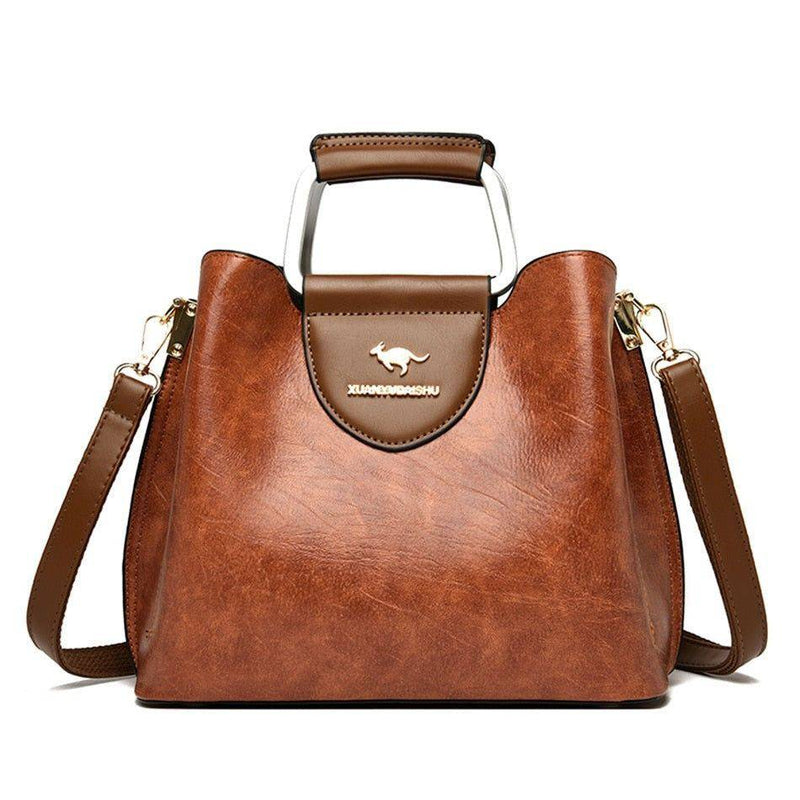 Alt text: Bolsa feminina de couro violet com alça ajustável e elegante.