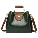 Bolsa feminina verde-escuro com detalhe marrom, alça de mão estruturada e alça transversal ajustável