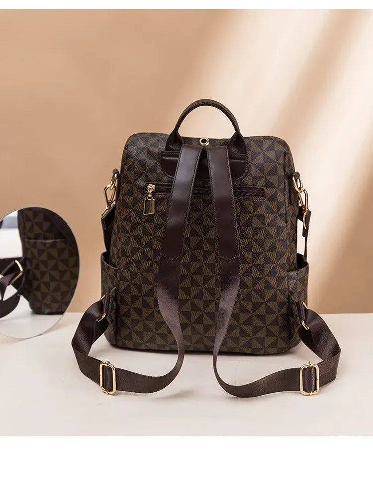 Alt text: Bolsa mochila feminina preta com detalhes geométricos em couro.