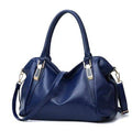 Alt text: Bolsa tiracolo de couro estruturada na cor preta elegante.