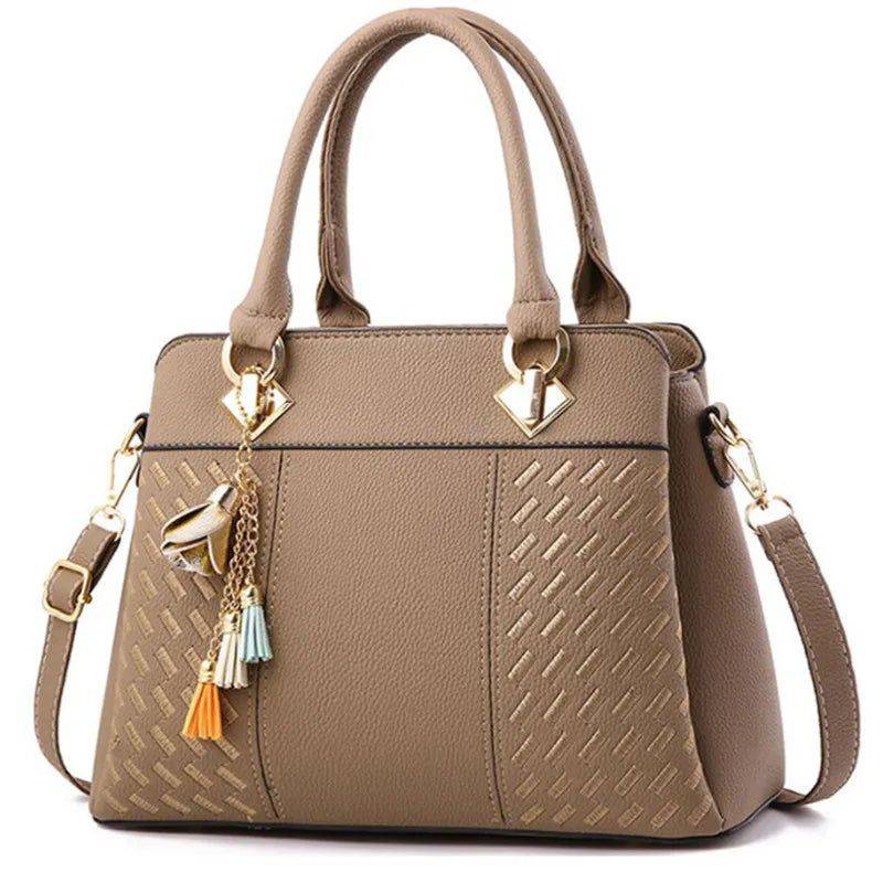 Bolsa feminina de couro marrom com alça transversal removível.