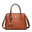 Bolsa de couro caramelo com alças manuais e detalhe frontal dourado