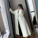 Sobretudo comprido em lã com tom off-white, sobre vestido preto