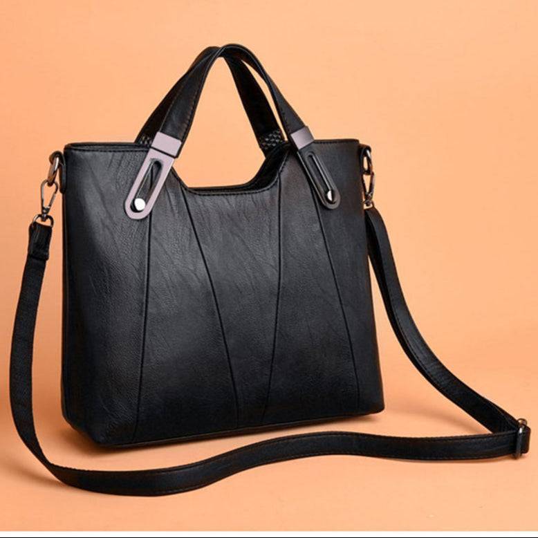 Bolsa preta de ombro com alça transversal removível em couro.