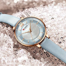 Relógio de pulso feminino com mostrador azul claro, numeração romana e pulseira de couro azul