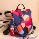 Mochila feminina com estampa geométrica em cores vibrantes: rosa, azul-marinho, laranja e creme