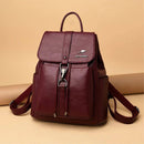 Mochila e bolsa feminina de couro 2 em 1 na cor vinho, com aba frontal fechada e fecho de gancho, exibindo suas alças ajustáveis e logotipo de canguru em relevo.