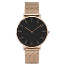 Relógio feminino minimalista com pulseira de malha dourada e mostrador preto