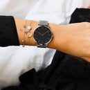 Relógio minimalista com pulseira de aço, combinado com pulseiras de prata