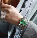 Relógio de pulso aço inoxidável com mostrador verde, pulseira metálica, em uso no pulso