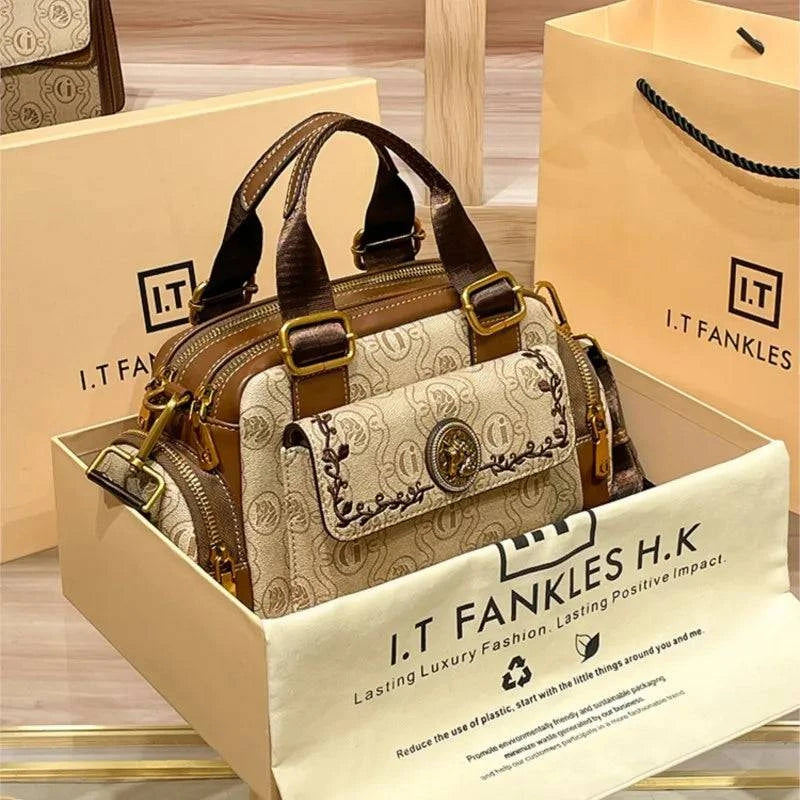 "Bolsa Baú Feminina preta em couro com alça ajustável."