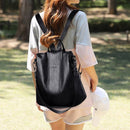 Mulher usando mochila de couro preta com alças para os ombros em ambiente externo
