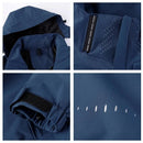 Jaqueta corta-vento azul-marinho com capuz ajustável, fechos de velcro, punho elástico e furos de ventilação.