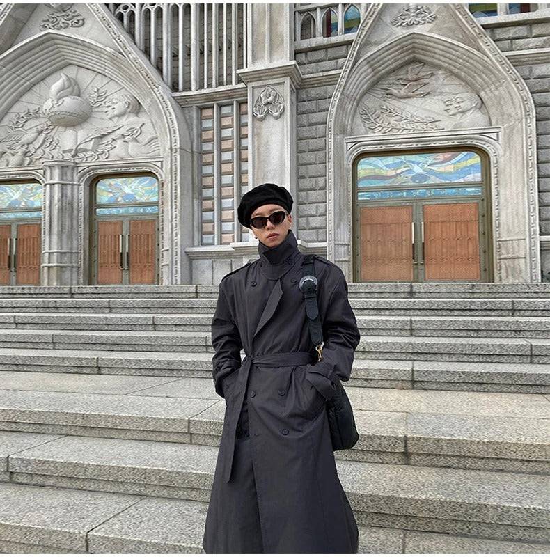 Homem usando sobretudo masculino preto tech com cinto em frente a uma catedral. Estilo moderno e sofisticado para o inverno.