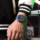 Relógio quadrado com caixa azul e pulseira de silicone em pulso masculino