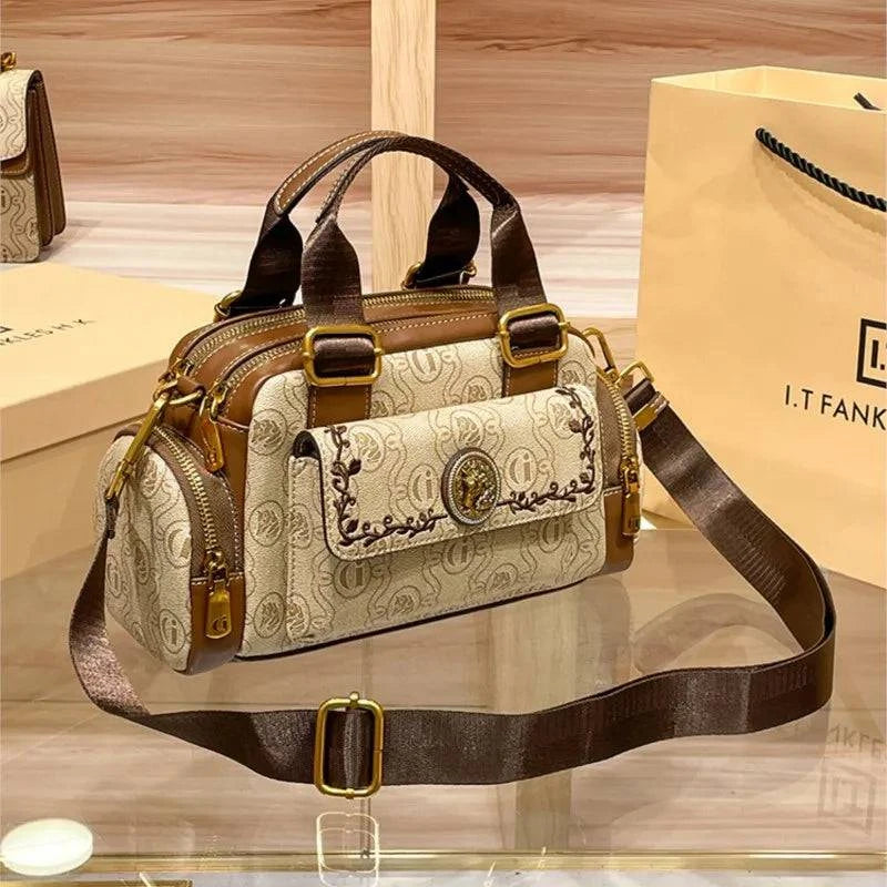 "Bolsa baú feminina preta em couro com alça ajustável."