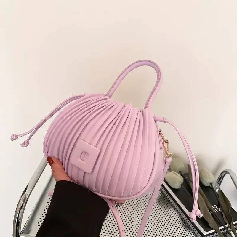 Alt text: Bolsa feminina bucket texturizada em tom neutro elegante.