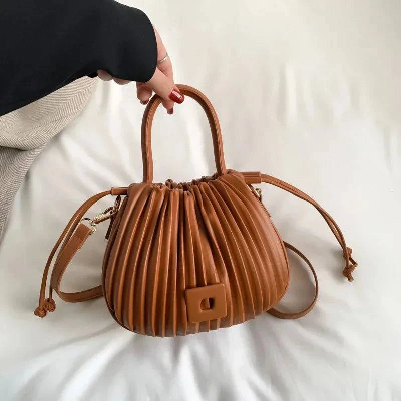 Alt text sugerido: Bolsa feminina bucket texturizada em tom neutro elegante.