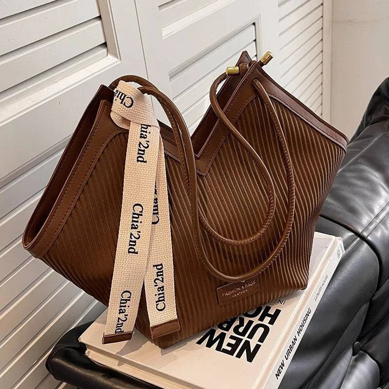 Alt text: Bolsa Tote feminina em couro Royale marrom claro.