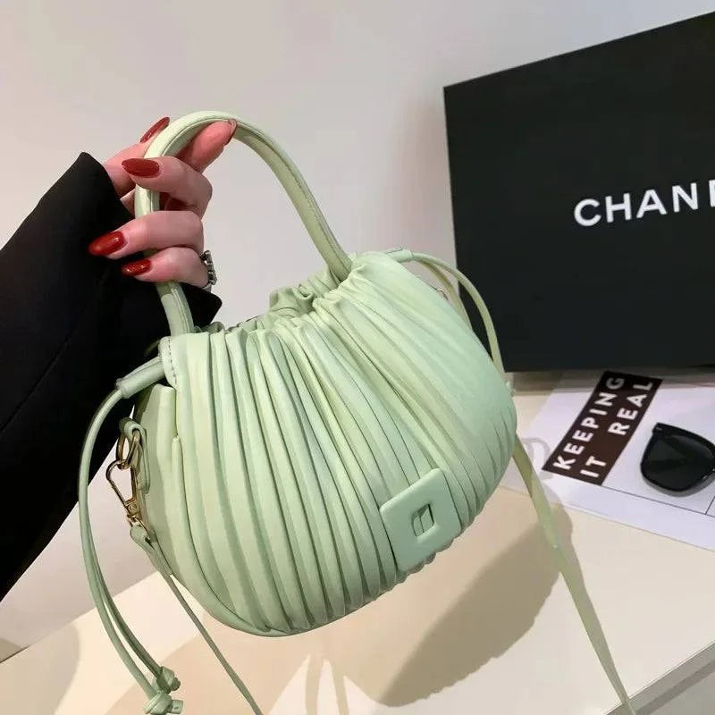 Alt text: Bolsa feminina bucket texturizada em tom neutro elegante.
