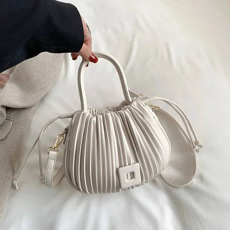 Alt text: Bolsa feminina bucket texturizada em tom neutro elegante.