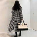Mulher de costas usando sobretudo longo pied-de-poule preto e branco com bolsa tote bicolor