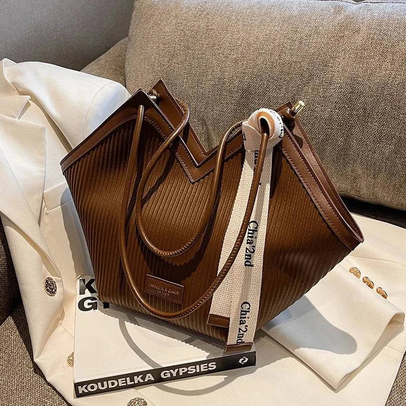 Alt text: Bolsa Tote feminina em couro Royale marrom elegante.