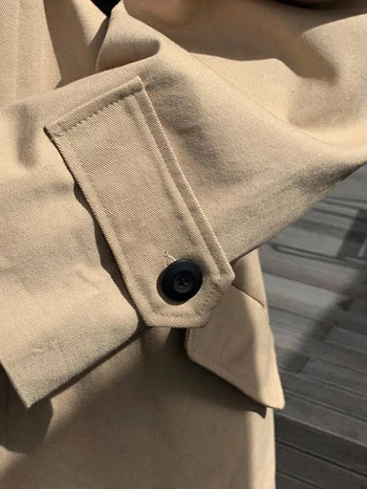 Fecho de botão no punho do sobretudo masculino creme. Design funcional e sofisticado para estilo casual clássico.
