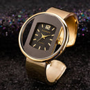Relógio feminino dourado com mostrador retangular preto dentro de caixa circular e pulseira bracelete