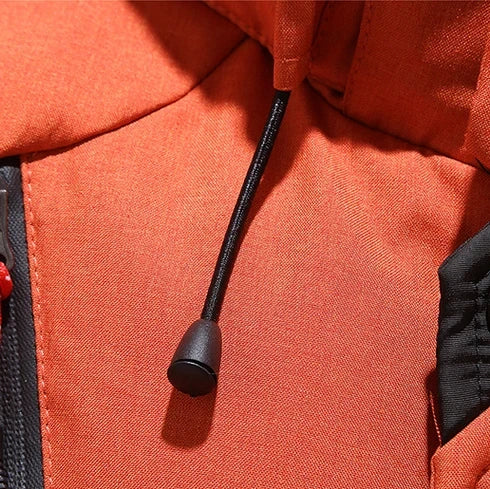 Close-up da Jaqueta Masculina Parka Acolchoada com Capuz e Zíperes Táticos laranja da Zellum, mostrando um cordão preto com fecho de plástico saindo de uma costura, um zíper preto visível e acabamento e textura detalhada do tecido.