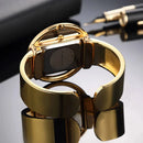 Relógio dourado com pulseira bracelete larga e mostrador retangular preto