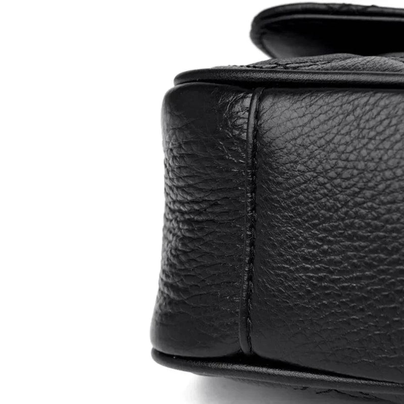 Alt text: Bolsa tiracolo acolchoada preta com corrente de metal.