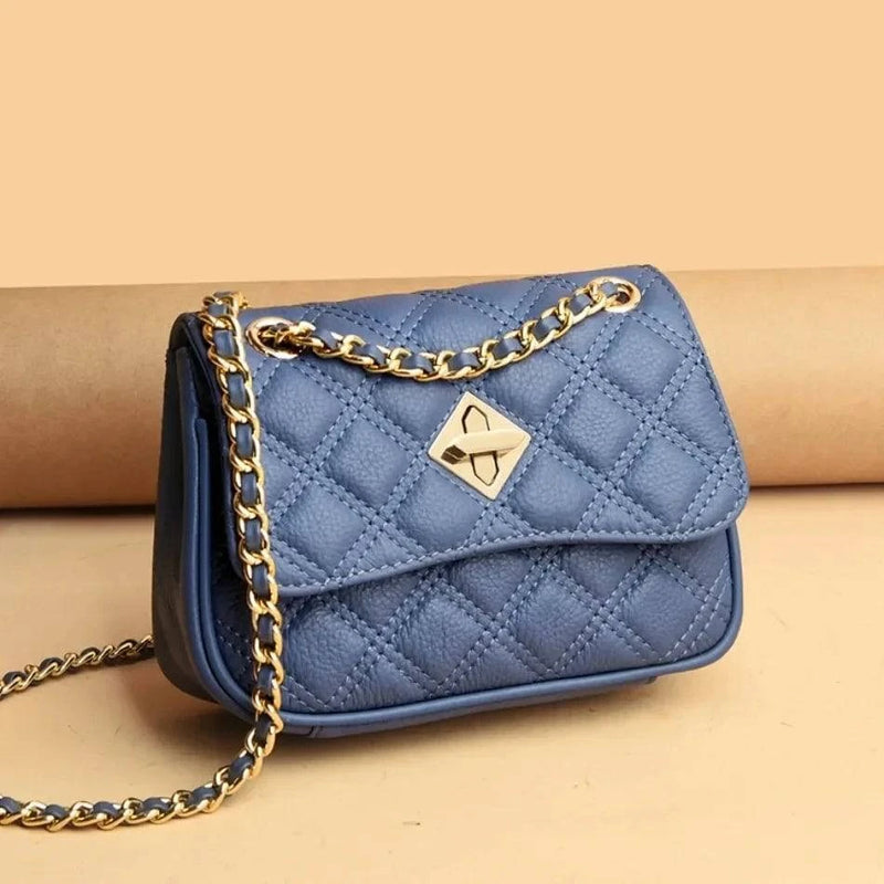 Alt text: Bolsa tiracolo acolchoada preta com corrente de metal.
