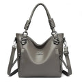 Alt text: Bolsa feminina de couro tote marrom com alça dupla elegante.