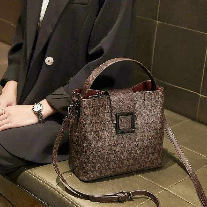 Alt text: Bolsa transversal feminina em couro sintético preto da marca Vogue.