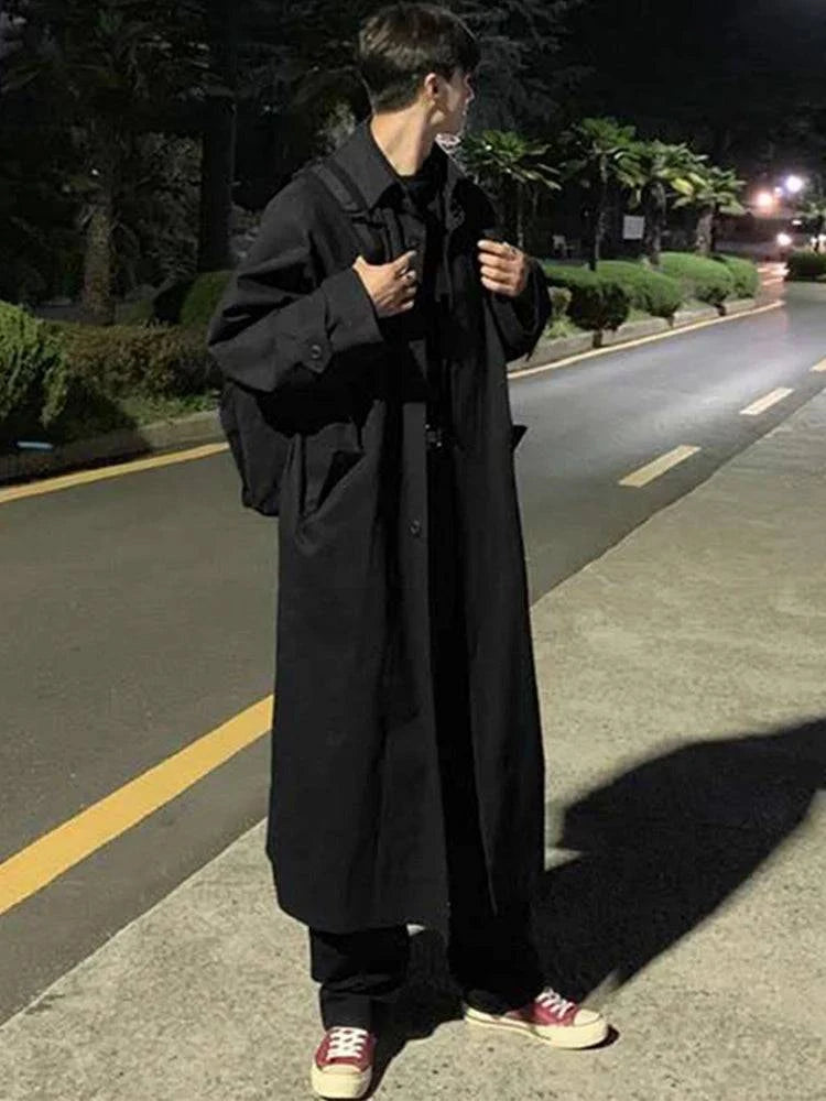 Sobretudo Masculino Longo Simples preto estilo europeu usado à noite com tênis vermelhos. Ideal para moda masculina casual e dias frios.