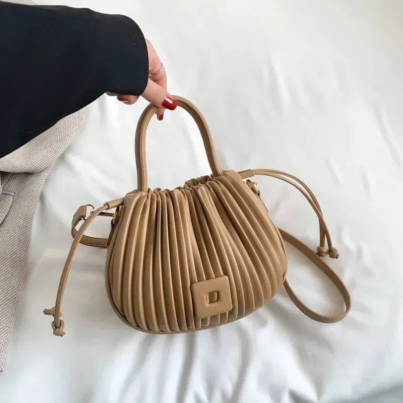 Alt text: Bolsa feminina bucket texturizada em tom neutro elegante.