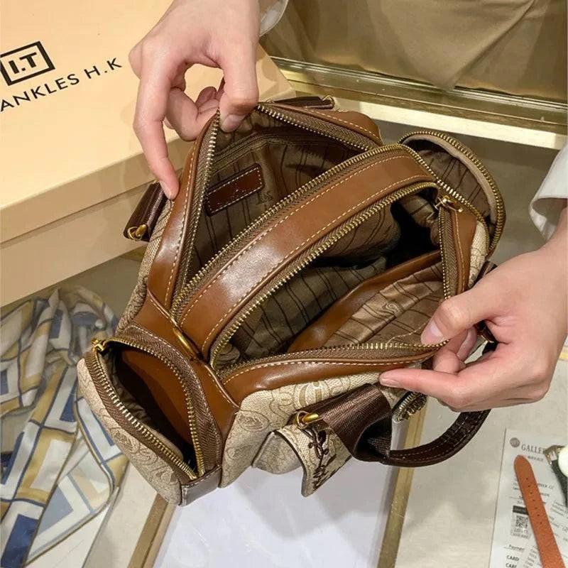 Bolsa baú feminina preta em couro com alça ajustável.