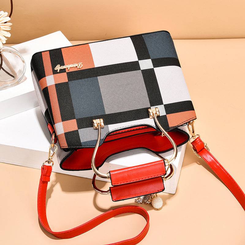 Alt text: Bolsa feminina de couro estruturada com estampa xadrez em tons neutros.