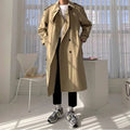 Sobretudo Masculino Longo Caqui com abotoamento duplo, estilo europeu, ideal para outono/inverno. Modelo veste peça em ambiente moderno.