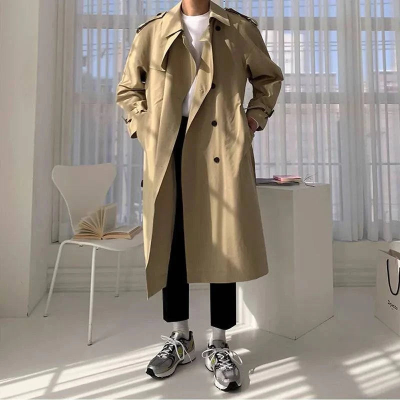 Sobretudo Masculino Longo Caqui com abotoamento duplo, estilo europeu, ideal para outono/inverno. Modelo veste peça em ambiente moderno.