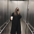 Mulher usando sobretudo preto longo em selfie no elevador