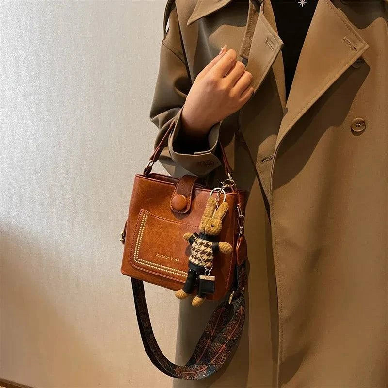 "Bolsa Tote feminina pequena em tom neutro com alça transversal."