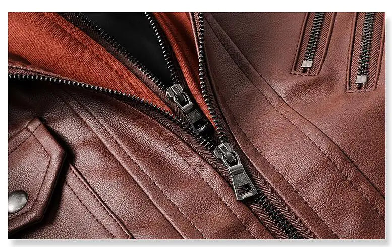 Close-up da Jaqueta de Couro Masculina com Capuz da Zellum, destacando a costura detalhada, os zíperes prateados, a aba com botão de pressão e o couro liso e levemente brilhante. O forro interno marrom-avermelhado é parcialmente visível.